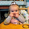 Alice a rejoint le concours — aidez-le/la à gagner de superbes lots ! baby, child, blue_eyes, pink_bow, gold_bangles, high_chair, chewing, cute, indoor, furniture, table, clothing, patterned_shirt, playful, portrait, face, hands, smiling, home, decor