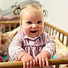 Alice a rejoint le concours — aidez-le/la à gagner de superbes lots ! baby, child, smile, pigtails, crib, wooden_rail, indoor, happy, cute, clothing, long_sleeves, face, hands, infant, person, toy, blurred_background, home, pink, portrait