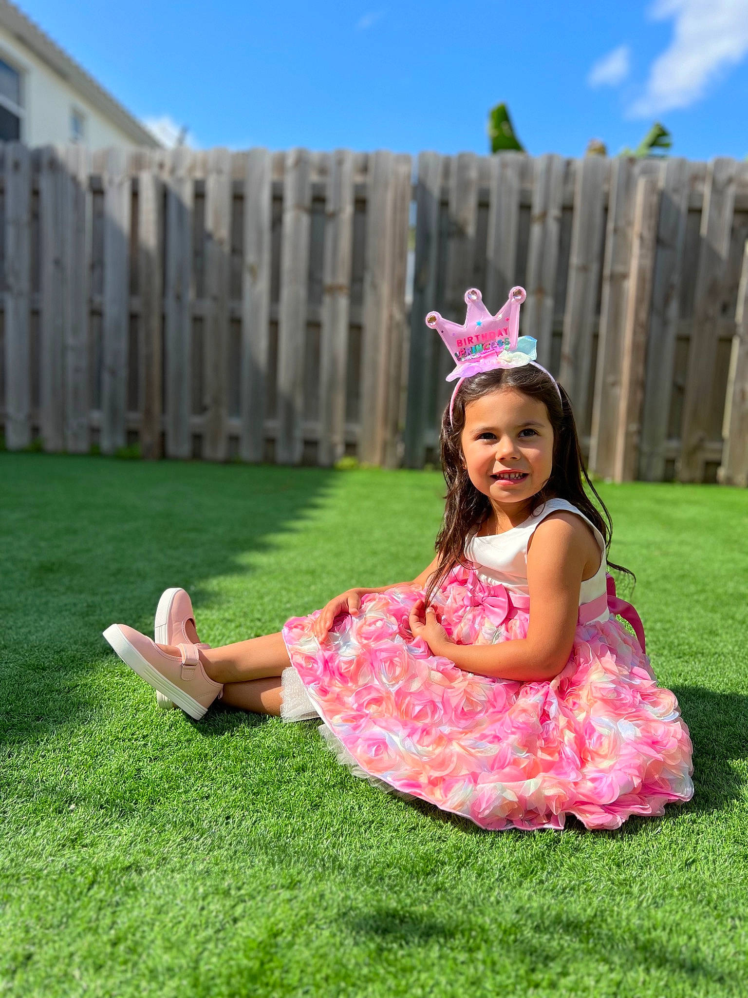 Lina is registered to the contest to win money with this photo: baby_toddler_clothing, dress, face, fence, flash_photography, grass, grass_family, grassland, happy, headpiece, joy, leisure, meadow, people_in_nature, person, pink, plant, recreation, sky, smile
