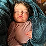 baby, sleeping, blanket, pink_clothing, cozy, child, infant, polka_dots, soft_texture, peaceful, portrait, closeup, cute, resting, hands, indoor, warm, comfort, tiny, face