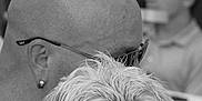 Jack a rejoint le concours — aidez-le/la à gagner de superbes lots ! black_and_white, man, bald, glasses, earring, dog, small_dog, fluffy, bandana, pet, portrait, holding, close_up, indoor, people, blurred_background, face, expression, companion, affection