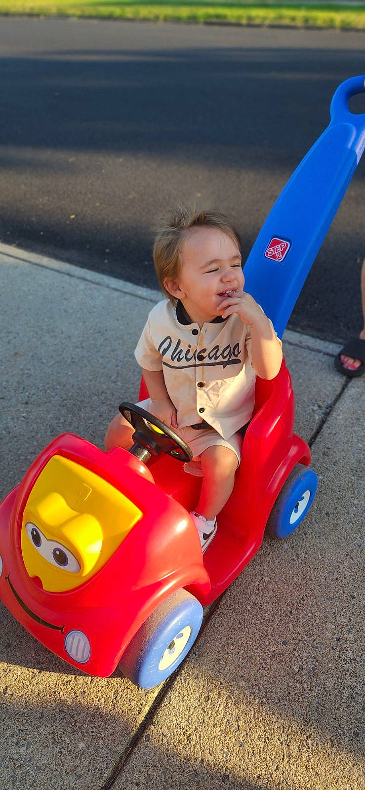 Nicholas is registered to the contest to win money with this photo: automotive_design, automotive_tire, automotive_wheel_system, child, fun, happy, motor_vehicle, person, photograph, product, recreation, red, riding_toy, smile, snapshot, tire, toddler, toy, vehicle, wheel