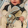 baby, infant, smiling, plush_toy, baby_seat, clothing, straps, happy, cute, child, indoors, comfort, soft_toy, seat, person, face, head, socks, blanket, cuddly