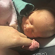 Harley is registered to the contest to win money with this photo: newborn, infant, baby, sleeping, car_seat, blanket, hand, finger, holding, portrait, close_up, soft_light, toddler_like, skin, face, head, sleeve, safety_label, cozy, peaceful