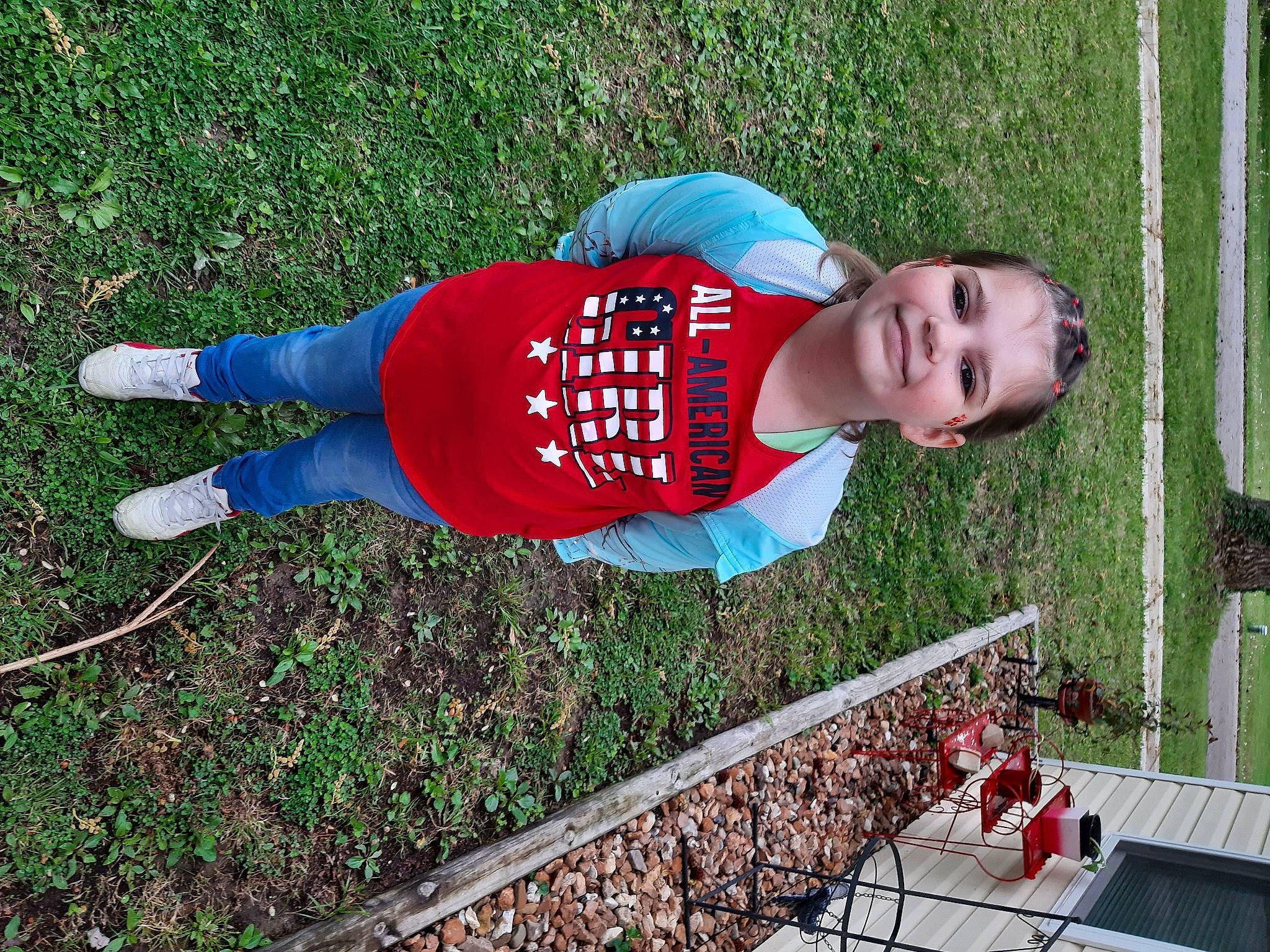 Karly is registered to the contest to win money with this photo: carmine, child, electric_blue, fence, fun, grass, hat, joy, leisure, people_in_nature, person, player, recreation, smile, soil, t_shirt, vertebrate, walking_shoe