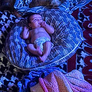 Taylyn is registered to the contest to win money with this photo: baby, pillow, blanket, dog, carpet, floor, indoor, sleeping, pattern, diaper, soft, cozy, pet, resting, child, animal, comfort, cute, laying, blue_light