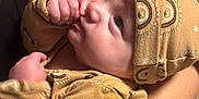 Taylyn joined the competition — help win amazing prizes! arm, baby, black_shirt, child, closeup, clothing, curious, hand, hat, holding, indoor, infant, patterned, person, portrait, skin, stack, sucking_thumb, video_games, yellow