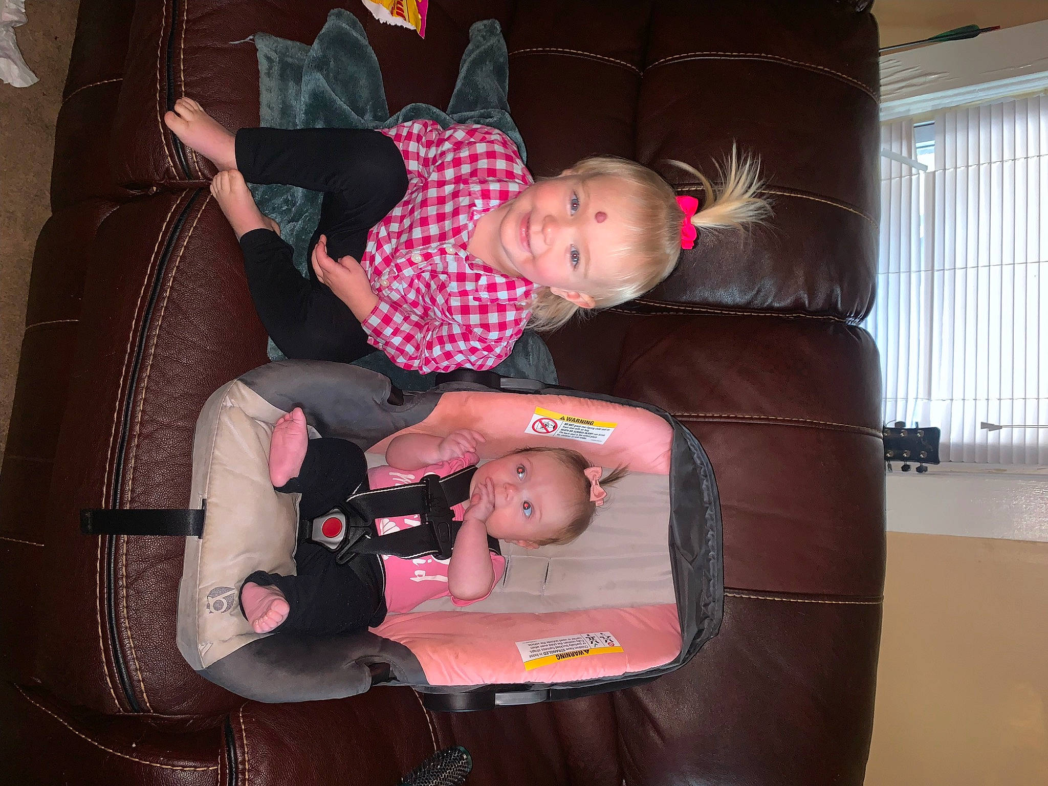 Lindsey is registered to the contest to win money with this photo: baby, baby_carriage, baby_products, baby_toddler_clothing, child, comfort, fun, joy, lap, person, pink, product, sitting, smile, toddler, window, window_blind