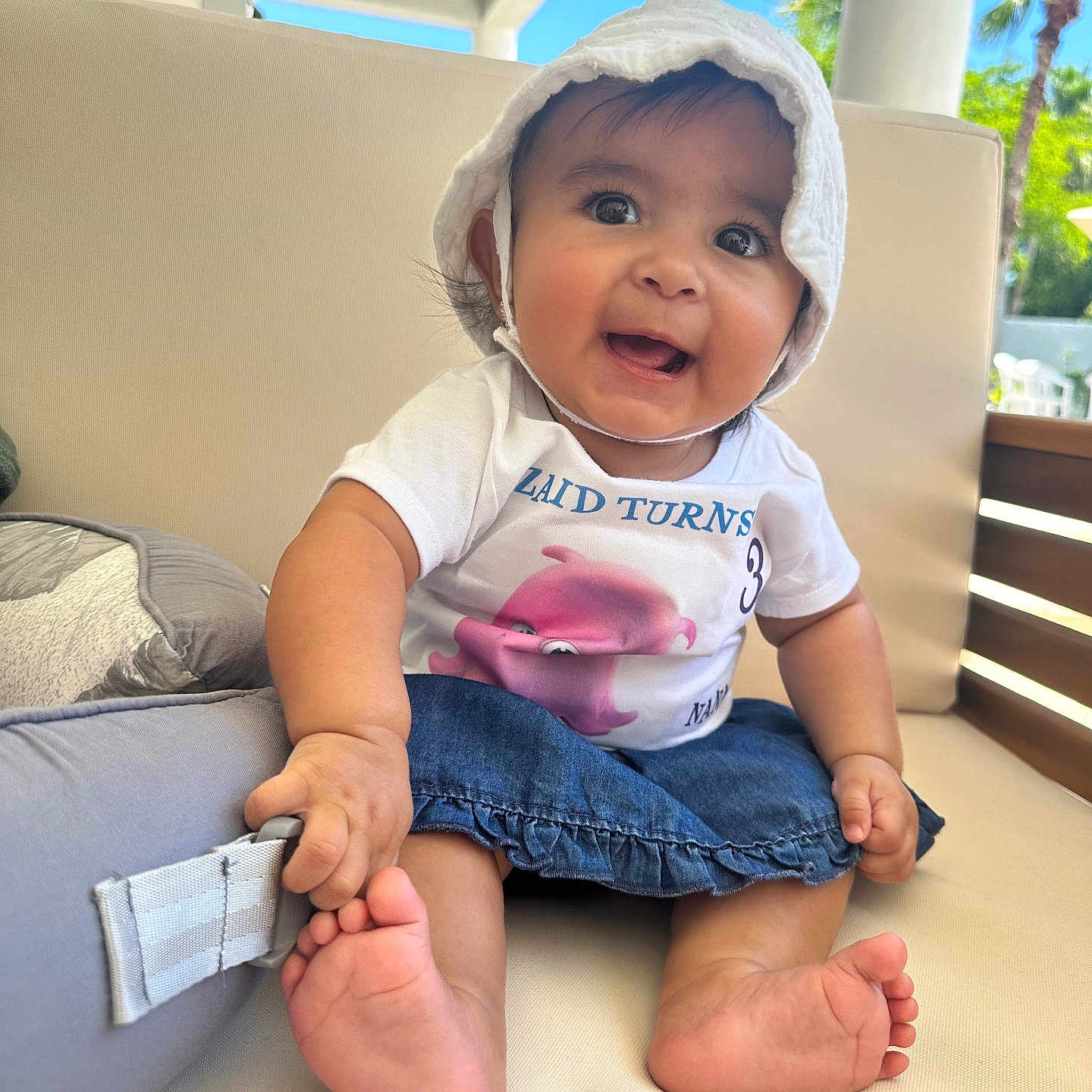 Nahara Rosario joined the competition — help win amazing prizes! baby, barefoot, blue_sky, child, couch, cute, denim_skirt, foot, hand, happy, hat, indoors, infant, outdoor_view, palm_trees, person, portrait, smiling, sunlight, tshirt