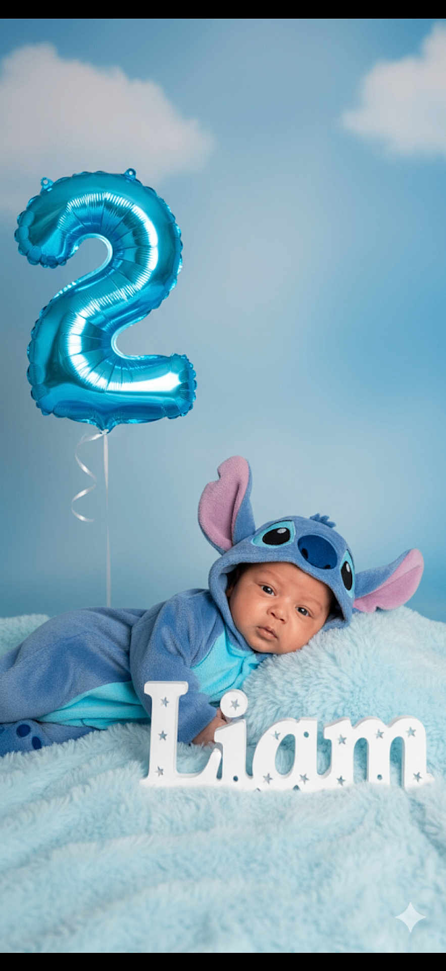 Liam joined the competition — help win amazing prizes! baby, blue, costume, stitch, balloon, number_two, fluffy_blanket, letters, name, lying_down, portrait, cute, child, soft_toys, decor, celebration, birthday, indoors, studio, background