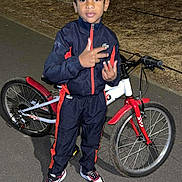 Maevan participe au concours pour gagner de l'argent avec cette photo : child, boy, bicycle, bike, tracksuit, sneakers, outdoor, night, tree, pavement, gesture, posing, flash, sportswear, casual, person, young, standing, expression, park
