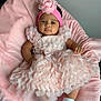 baby, infant, pink_dress, headband, flower, blanket, soft_texture, cute, child, footwear, socks, indoor, portrait, smiling, lying_down, comfortable, decorative, clothing, person, toddler