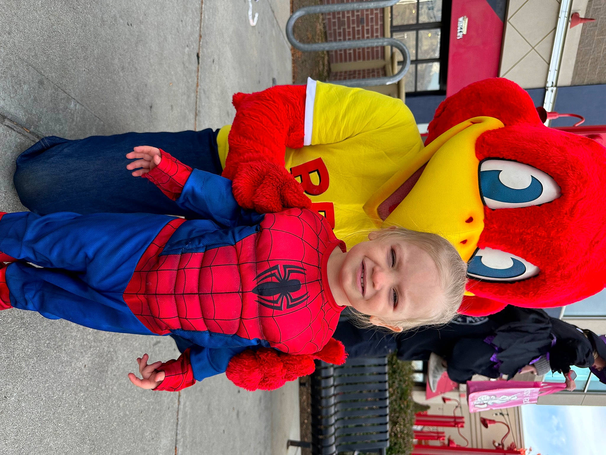 Everleigh is registered to the contest to win money with this photo: carmine, child, costume, electric_blue, event, fictional_character, fun, happy, joy, leisure, mascot, pattern, person, plush, red, smile, superhero, textile, toddler, tree