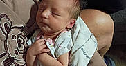 Oakley is registered to the contest to win money with this photo: newborn, baby, infant, sleeping, blanket, arms, hand, person, clothing, indoor, cozy, tender, gentle, peaceful, closeup, portrait, human, rest, soft, comfort