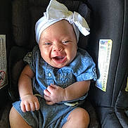 Syrenity is registered to the contest to win money with this photo: baby, car_seat, child, infant, smiling, white_bow, blue_outfit, happy, cute, person, seat, clothing, headwear, infant_clothing, sitting, young_child, portrait, indoors, closeup, joy