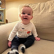 Cooper joined the competition — help win amazing prizes! baby, child, smiling, indoors, couch, lamp, halloween, shirt, socks, happy, portrait, infant, home, cozy, seated, cute, celebration, decor, person, young