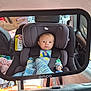 baby, car_seat, mirror, car_interior, blanket, child, infant, seatbelt, person, parent, phone, reflection, window, clothing, automobile, safety, travel, seat, headrest, hand
