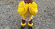Charlie is registered to the contest to win money with this photo: child, girl, outdoor, portrait, smiling, yellow_outfit, hair_bows, pigtails, cardigan, dress, ruffled_socks, black_shoes, standing, hands_on_cheeks, gravel, grass, playground, daylight, fashion, cute
