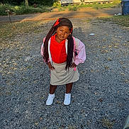 Charlie joined the competition — help win amazing prizes! child, girl, portrait, outdoor, standing, braids, red_shirt, pink_jacket, skirt, sneakers, gravel_driveway, house, neighborhood, mailbox, trash_bin, trees, sunlight, fashion, serious_expression, full_body