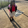 child, girl, school, backpack, braids, hair_bow, leopard_print, polo_shirt, cardigan, skirt, shoes, peace_sign, parking_lot, sidewalk, pavement, sunlight, long_shadow, outdoor, car, portrait