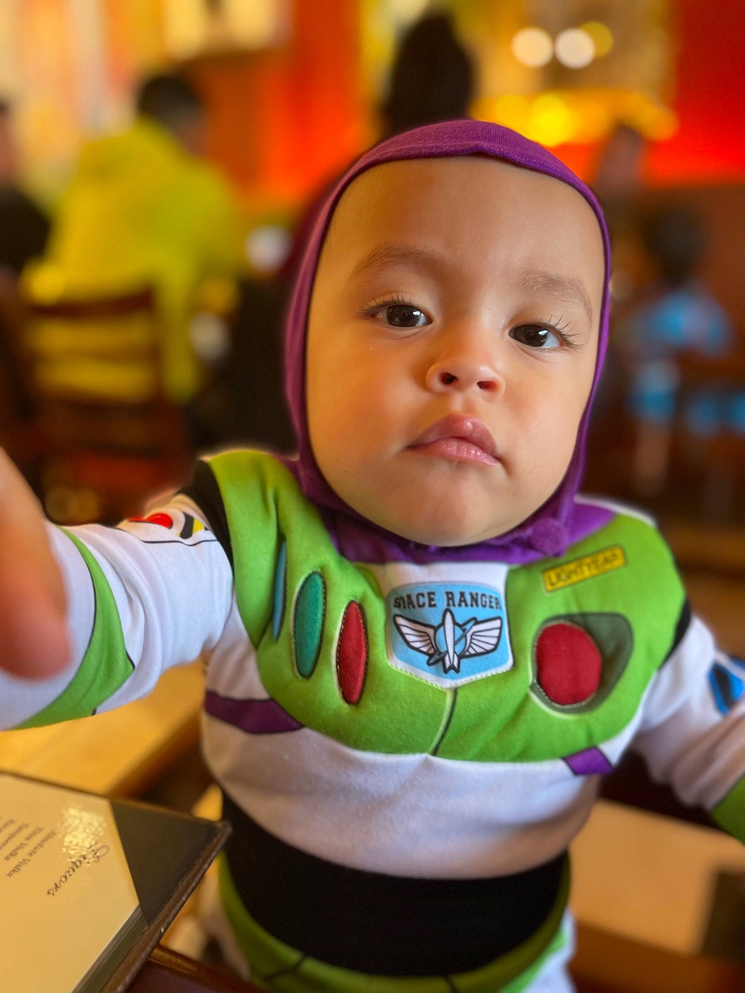 Mathias is registered to the contest to win money with this photo: baby, baby_products, bib, cheek, child, facial_expression, fun, gadget, hairstyle, happy, kindergarten, leisure, person, personal_protective_equipment, play, recreation, room, sitting, skin, t_shirt