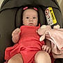 Ella participe au concours pour gagner de l'argent avec cette photo : baby, infant, car_seat, pink_dress, plush_toy, hair_bows, child, seatbelt, warning_label, indoor, cute, wide_eyes, soft_toy, clothing, person, small_hands, legs, sitting, car_safety, portrait