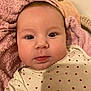baby, infant, face, close_up, pink_towel, heart_pattern, clothing, cute, newborn, child, portrait, skin, eyes, expression, indoor, soft_texture, head, young, person, warm
