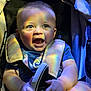 baby, infant, child, car_seat, stroller, seat_belt, smile, laughing, rainbow_light, colorful, holding_shoe, shoe, chubby_arms, onesie, clothing, closeup, portrait, soft_lighting, fabric, buckle