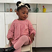 Aëlla a rejoint le concours — aidez-le/la à gagner de superbes lots ! child, toddler, girl, pink_dress, tights, black_boots, hair_bows, sitting, chair, white_cabinet, potted_plant, photo_frame, interior, floor_tiles, portrait, expression, cute, fashion, smile, home