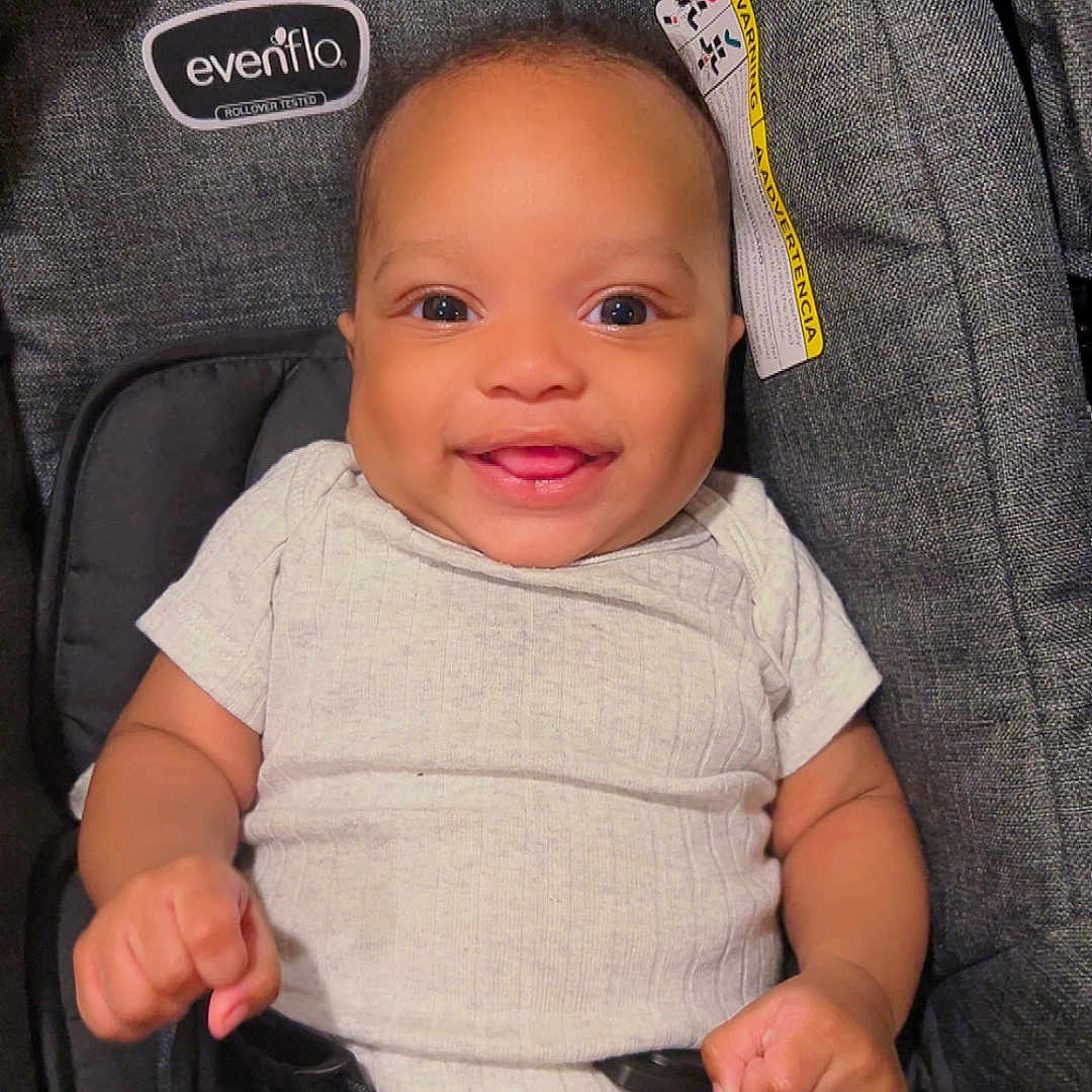 Kauron is registered to the contest to win money with this photo: baby, baby_hands, big_eyes, buckle, car_seat, close_up, cute, evenflo, fabric, happy, infant, onesie, portrait, safety_harness, seat_belt, smile, smiling, stroller, tan_skin, warning_label