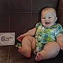 Jax is registered to the contest to win money with this photo: baby, child, chubby, couch, cute, face, feet, hands, happy, indoor, infant, leather, milestone, plaid_shirt, portrait, sign, sitting, six_months, smiling, toy