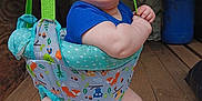 Jax is registered to the contest to win money with this photo: animal_pattern, baby, child, clothing, colorful, cute, drool, face, feet, green_straps, happy, indoor, infant, jumper, legs, person, smiling, suspend, white_towel, wooden_floor