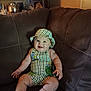 Jax is registered to the contest to win money with this photo: baby, books, child, clothing, couch, cute, decor, furniture, happy, hat, indoors, leather, living_room, person, plush, portrait, shelf, sitting, skin, smiling