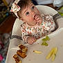 baby, bodypart, bread, clothing, cream, dessert, eating, face, finger, food, fruit, hand, hat, head, icing, meal, pear, person, plant, produce