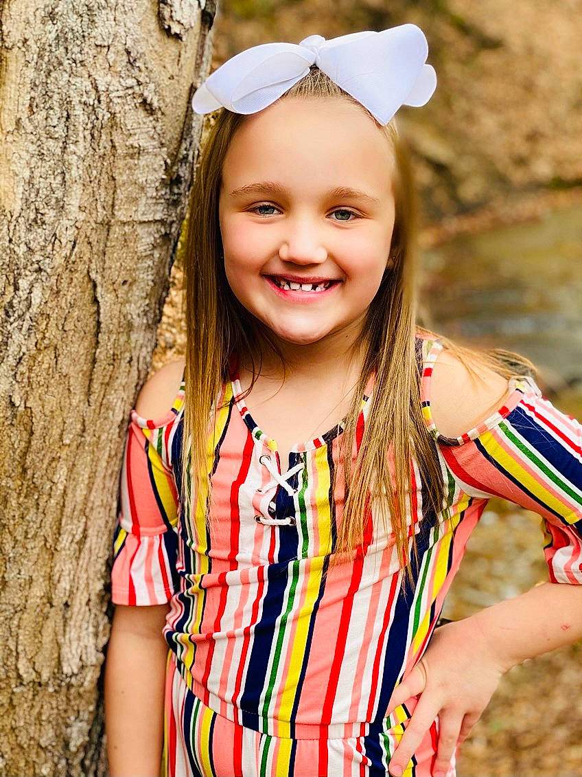 Kyla is registered to the contest to win money with this photo: beauty, child, face, facial_expression, fashion, fun, grass, happy, head, headwear, human, jewellery, joy, long_hair, organ, people_in_nature, person, smile, summer, toddler