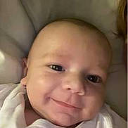 Massimo participe au concours pour gagner de l'argent avec cette photo : baby, smiling, face, infant, blanket, white_clothing, portrait, closeup, cute, child, young, skin, head, eyes, person, happy, indoors, soft, cozy, newborn