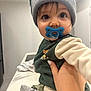 Pablo a rejoint le concours — aidez-le/la à gagner de superbes lots ! baby, child, pacifier, beanie, hat, pom_poms, hand, indoor, clothing, green, white, tattoo, cute, face, person, sitting, infant, young_child, portrait, closeup