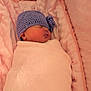 newborn, baby, sleeping, blanket, pink, purple_hat, knit_hat, cozy, soft, infant, cute, resting, wrapped, child, portrait, indoors, face, peaceful, warm, cushion