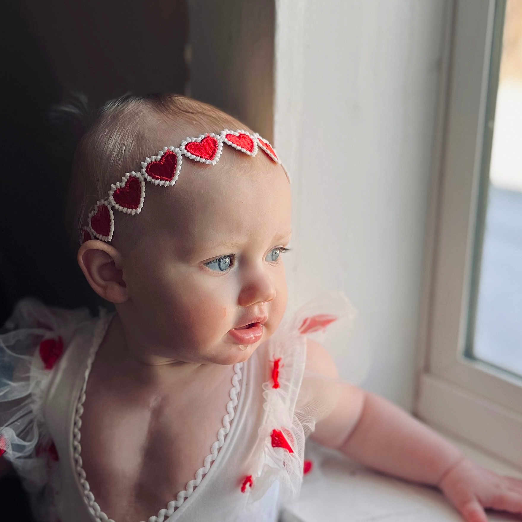 Lucy is registered to the contest to win money with this photo: accessories, baby, bodypart, clothing, dress, face, finger, hand, head, headband, jewelry, neck, necklace, newborn, person, photography, portrait, sitting, sunglasses, window