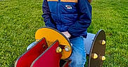 Marley a rejoint le concours — aidez-le/la à gagner de superbes lots ! child, grass, happy, jacket, jeans, outdoor, park, play, playground, portrait, scarf, seat, smile, sneakers, spring_rocker, sunglasses, sunlight, teeth, toy, tree