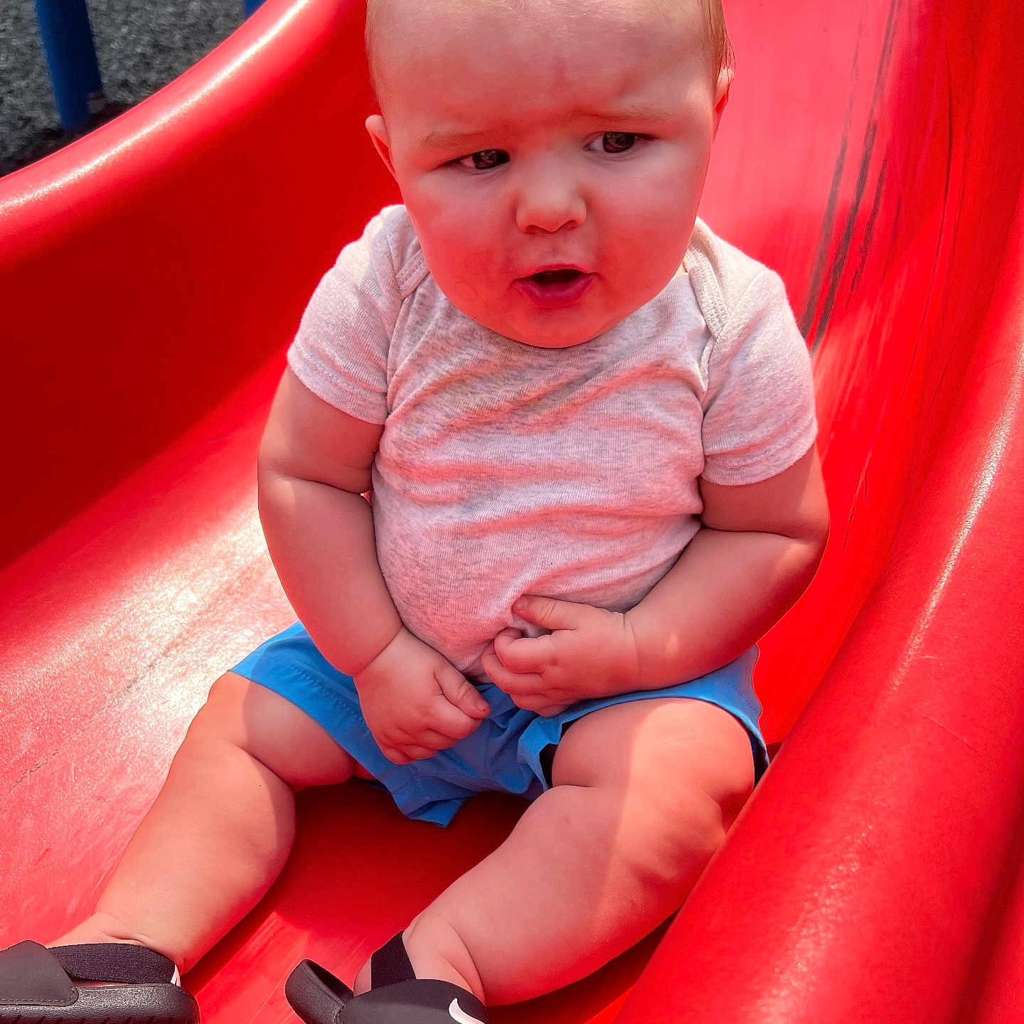 Easton joined the competition — help win amazing prizes! baby, baby_boy, child, clothing, curious_expression, footwear, grass, hands, legs, nike, outdoor, person, playground, red_slide, sandals, shirt, shorts, slide, summer, sunlight