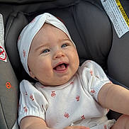 Melania joined the competition — help win amazing prizes! baby, infant, smiling, happy, car_seat, headband, white_outfit, cute, blue_eyes, child, portrait, indoors, soft_light, young, joyful, person, apparel, sitting, closeup, cute_expression