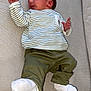 Siméo a rejoint le concours — aidez-le/la à gagner de superbes lots ! baby, infant, striped_clothing, olive_pants, white_socks, couch, textured_fabric, lying_down, curious_expression, indoors, child, person, newborn, comfortable, soft_lighting, casual_clothing, resting, young_child, home_interior, relaxed