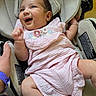 Krishni is registered to the contest to win money with this photo: baby, car_seat, cheerful, child, clothing, cushion, cute, expression, fabric, hand, happy, indoors, infant, person, pink_dress, portrait, seatbelt, skin, smiling, young_child