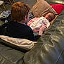 Jake joined the competition — help win amazing prizes! baby, blanket, carpet, carpeted_floor, child, couch, cozy, furniture, home, indoors, infant, living_room, person, pillow, red_hair, relaxing, sitting, sleeping, soft_lighting, storage_bins