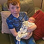Jake is registered to the contest to win money with this photo: baby, blanket, boy, child, comfort, couch, face, family, holding, home, indoor, newborn, person, pillow, red_hair, rest, shorts, sleeping, smile, tshirt