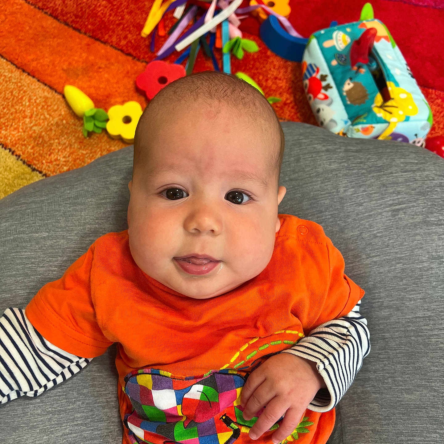 Leo is registered to the contest to win money with this photo: architecture, baby, building, clothing, couch, cushion, face, furniture, happy, head, homedecor, indoors, livingroom, person, photography, portrait, room, sitting, t_shirt, toy