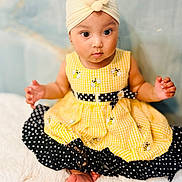 Mia joined the competition — help win amazing prizes! baby, child, dress, yellow, black, polka_dot, headband, flower, bee, sitting, feet, curious, cute, indoors, portrait, soft_background, fluffy, skin, hands, infant