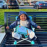Ky joined the competition — help win amazing prizes! baby, bench, book, car, child, daylight, footwear, grass, happy, hoodie, jacket, outdoor, park, parking_lot, person, residential_building, seat, smile, suburb, toy