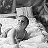 Orianne a rejoint le concours — aidez-le/la à gagner de superbes lots ! baby, child, bed, blanket, black_and_white, curious, cushion, furniture, indoors, infant, looking_up, monochrome, person, pillow, portrait, room, soft_light, toddler, wall_decor, young_child
